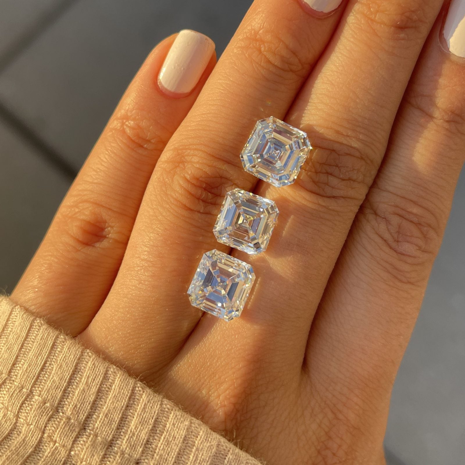 Three loose diamonds resting across a hand