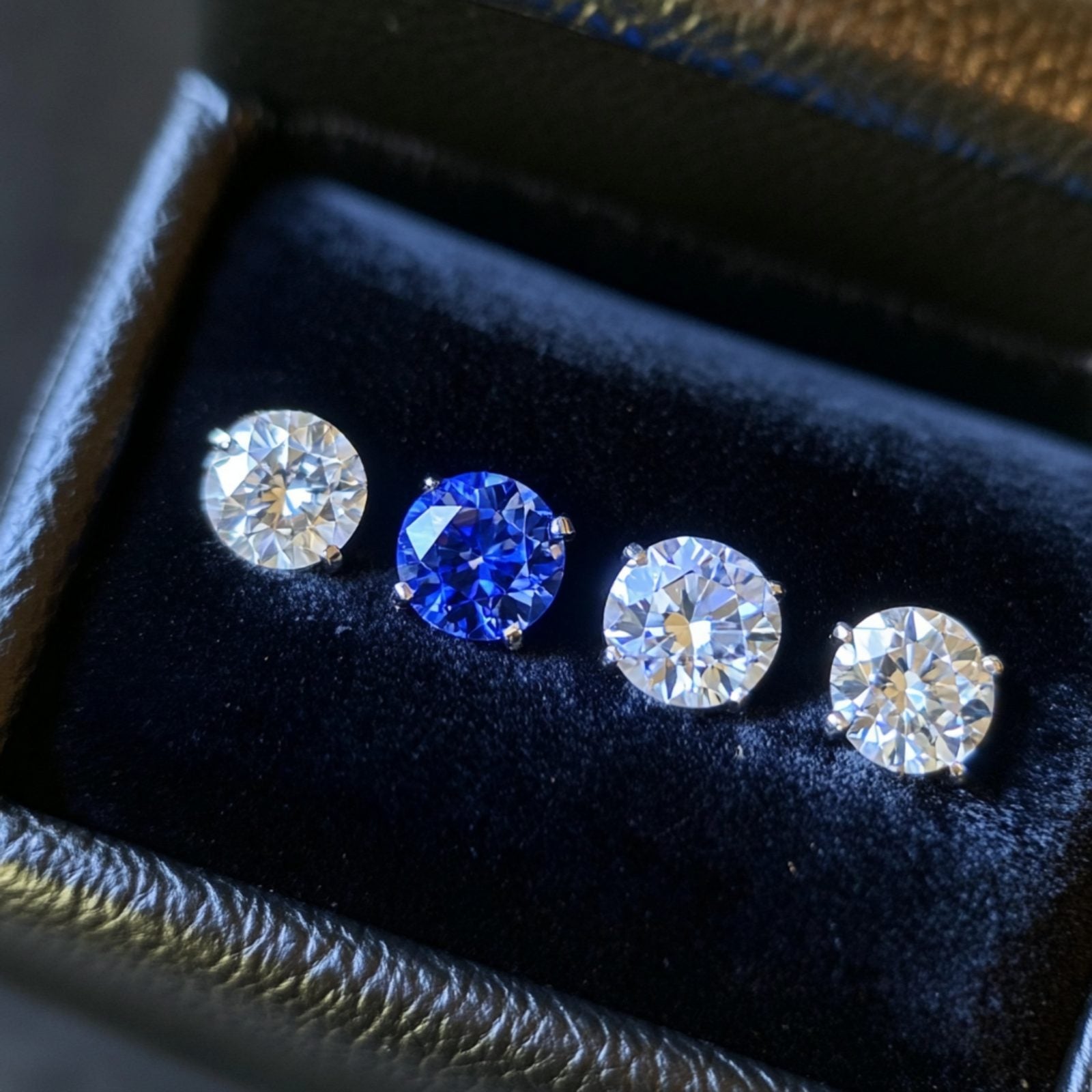 The Handoff — loose round diamonds and a sapphire resting in a velvet ring box